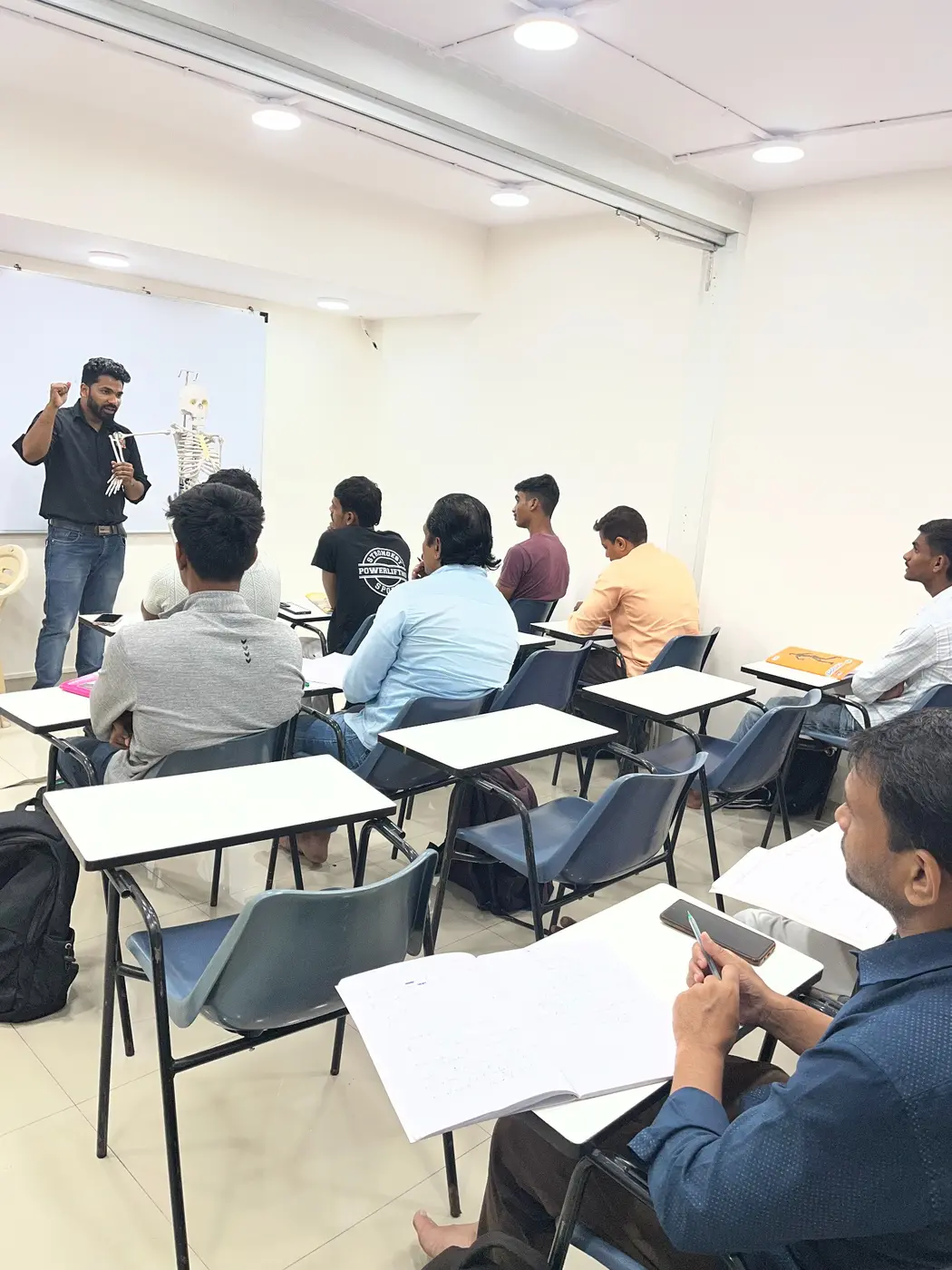 IFSI instructor teaching anatomy with a skeleton model in the classroom